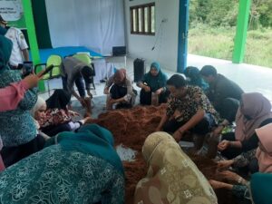 Peserta sosialisasi praktek membuat baglog, serbuk kayu yang sudah diayak dimasukan ke dalam kantong plastik dan dibentuk silider.